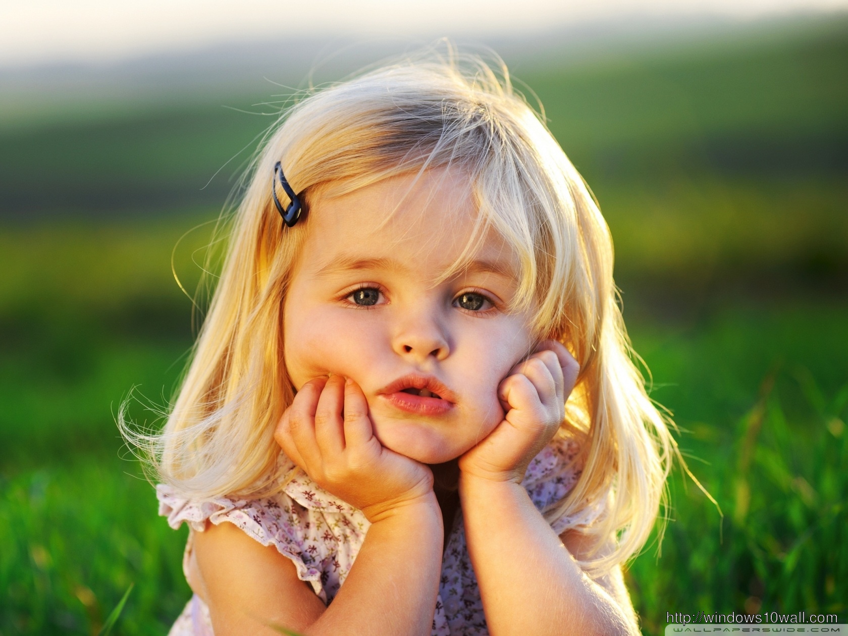Sweet Baby Girl with Hands on Face Background Wallpaper